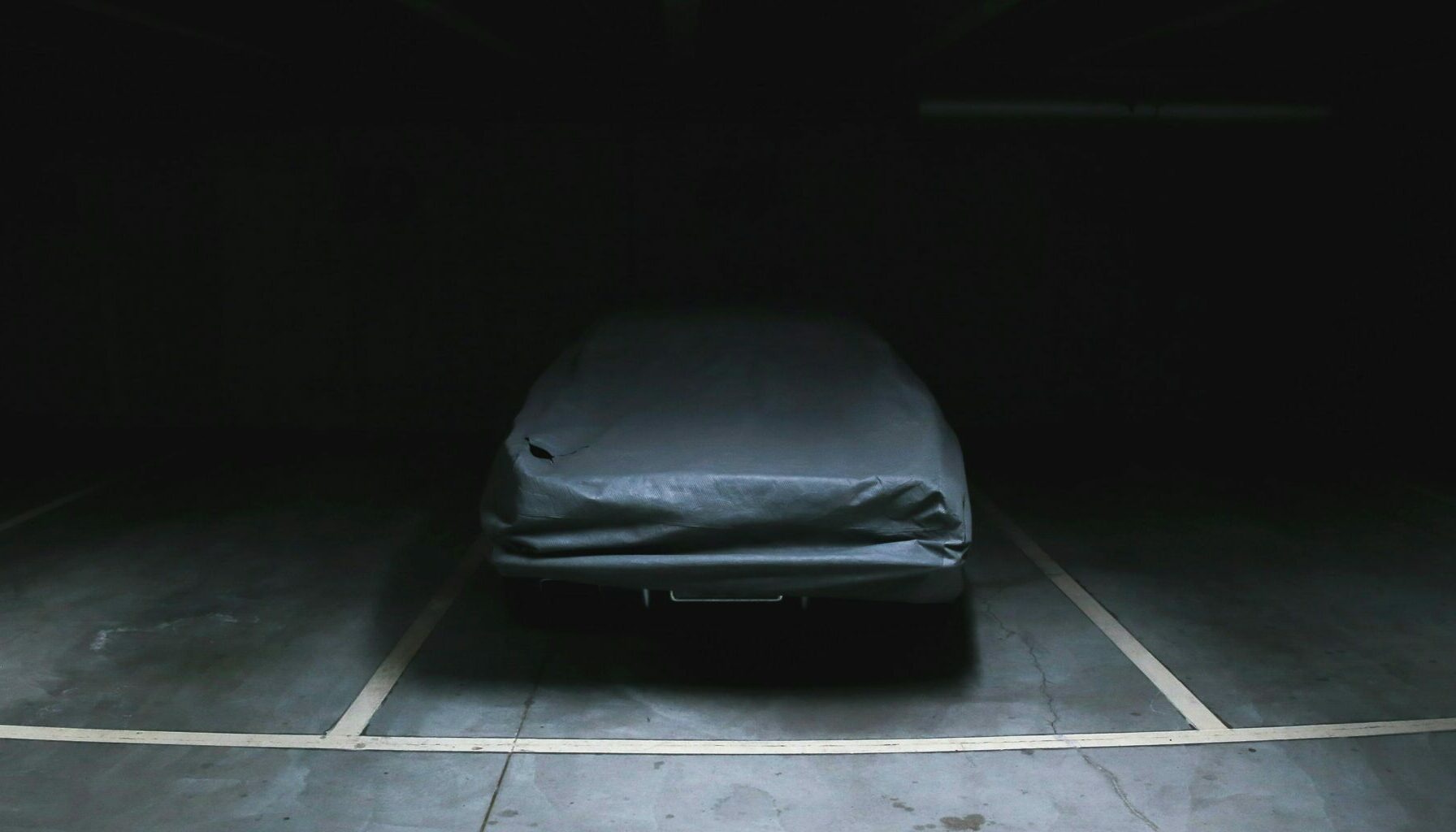 Voiture sombre cachée dans un parking sous-terrain très discrète